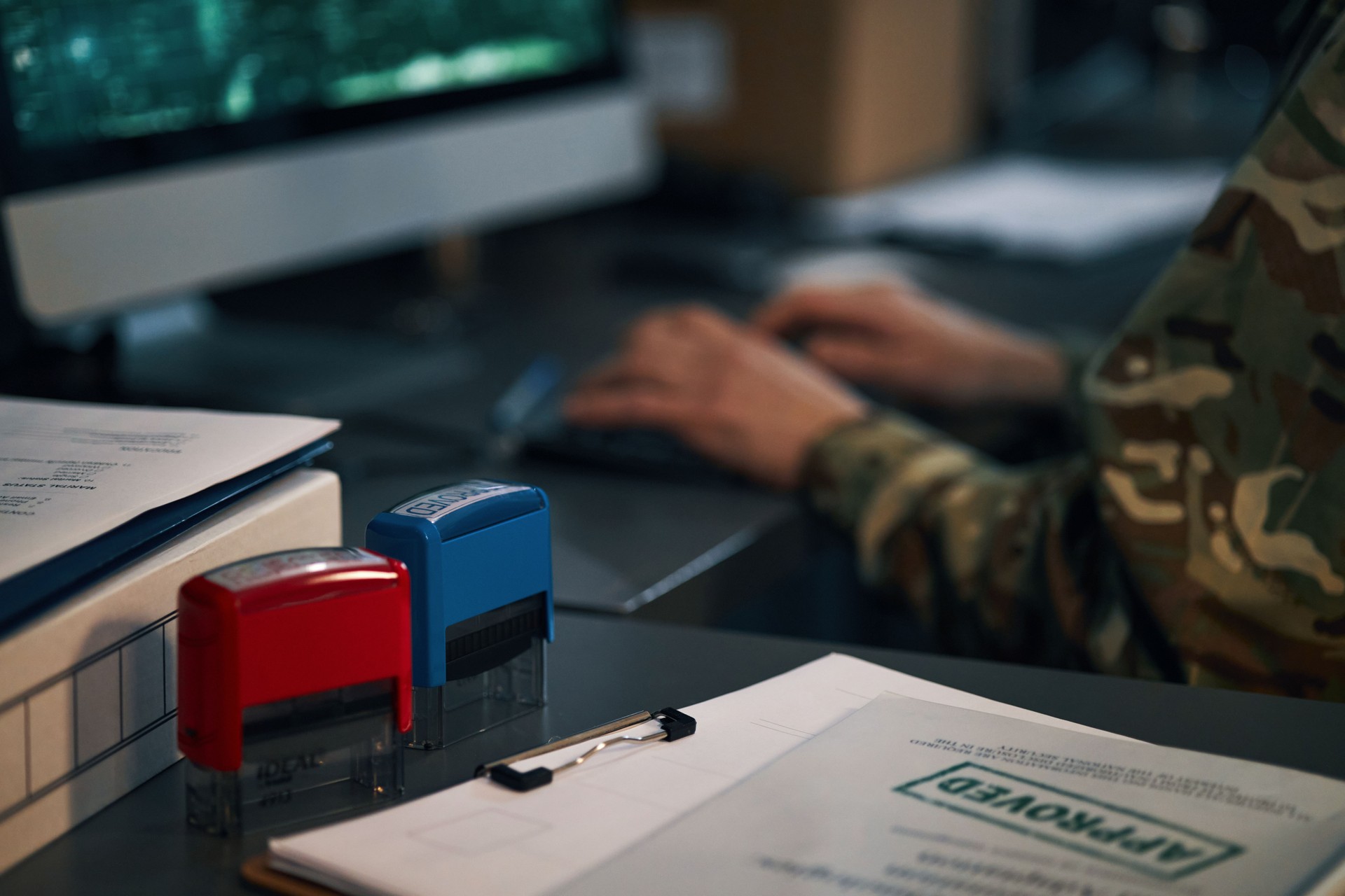 Person Working at Desk with Computer and Paperwork